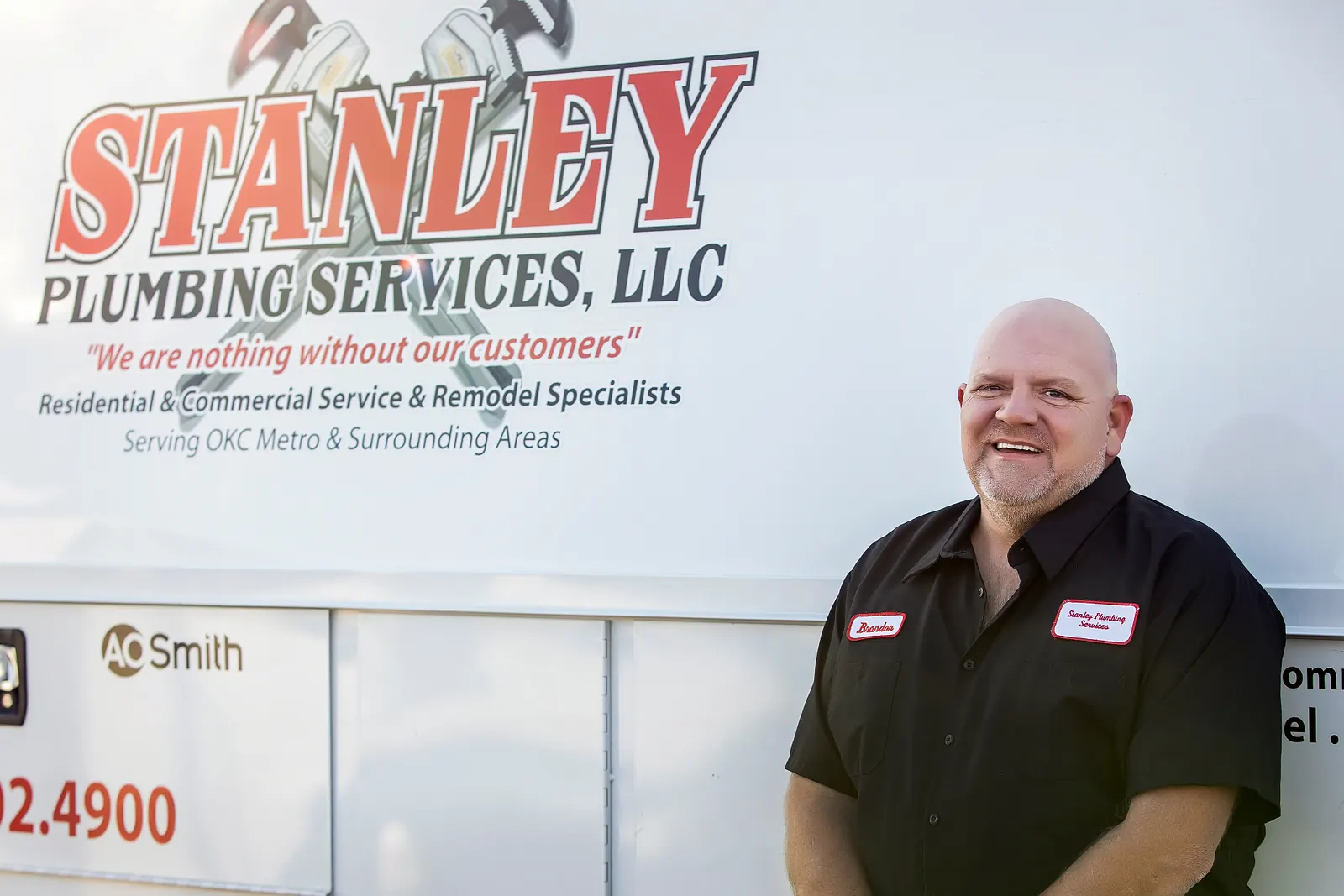Brandon, Stanley Plumbing Services technician, standing in front of a company service truck in Oklahoma City
