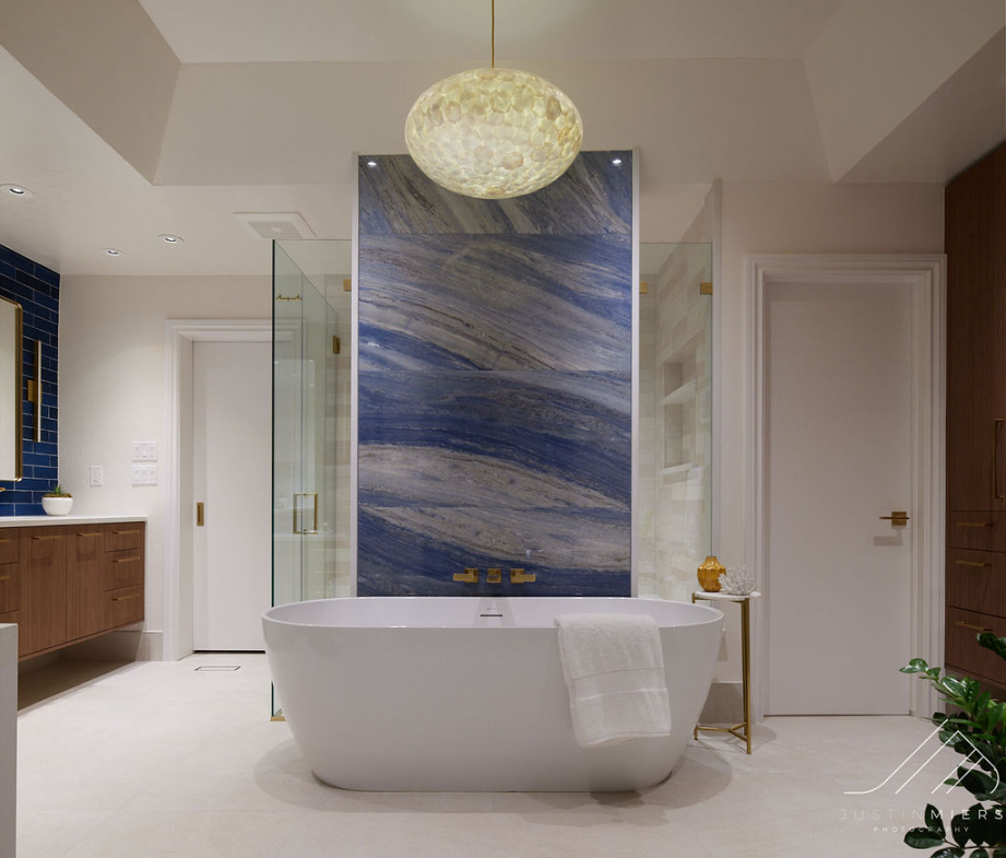 Luxury remodeled primary bathroom with freestanding tub and blue marble feature wall