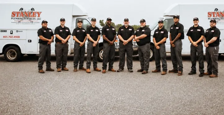 Stanley Plumbing team standing in front of service vehicles